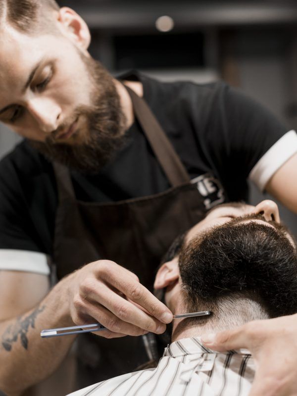 barber-shaving-customer-s-beard-with-razor
